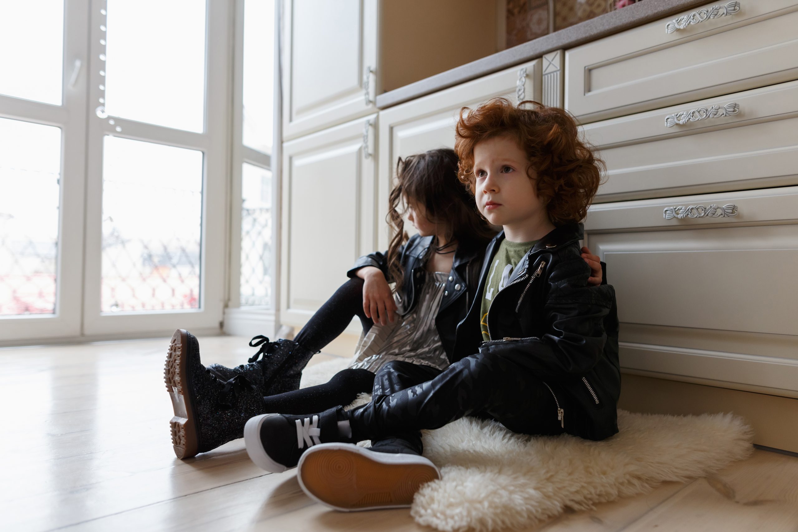 Boy and girl friends sit together on the floor and play.